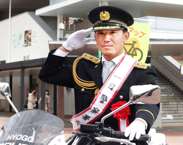 白バイに乗って敬礼する伊藤将司投手＝西宮市甲子園七番町