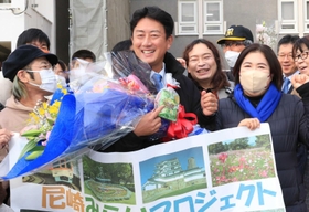 庁舎前で市民から花束を贈られて笑顔の松本真・尼崎市長（中央）＝尼崎市役所（撮影・斎藤雅志）