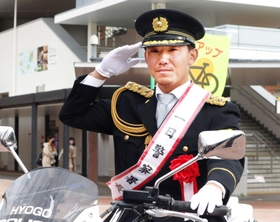 白バイに乗って敬礼する伊藤将司投手＝西宮市甲子園七番町