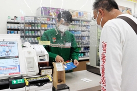電子マネーを買い求める客役に店員は啓発シートを使って説得した＝尼崎市潮江１