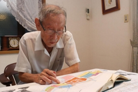 地図を見ながら砂かけ婆について語る市立尼崎高校の元教諭・天野一平さん＝尼崎市築地