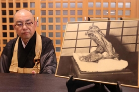 欣勝寺に伝わる「蛇の頭」の写真と谷口真弥住職＝三田市桑原 