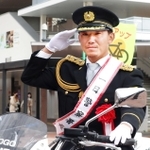 白バイに乗って敬礼する伊藤将司投手＝西宮市甲子園七番町