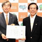 「子どもたちのために活用してほしい」と１千万円を市役所に届け、感謝状を受けた古田喜久治さん（右）＝伊丹市役所