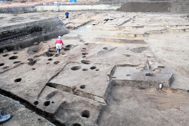 鉄を生産する工房だったとみられる建物跡（手前）。右奥は古墳時代中期の方墳＝兵庫県西宮市、津門大塚町遺跡