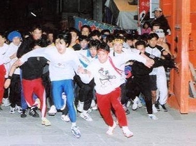 １９９８年の開門神事で「ガッツくんトレーナー」で駆け出す平尾さん（前列右、提供写真）