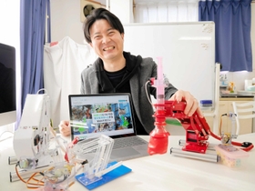アームロボットなどの教材を手に「ロボメイツ」について話す畠中裕介社長＝尼崎市南武庫之荘２