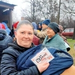 カイロを手にして笑顔を見せるウクライナの女性（提供）