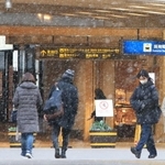 雪が降る中を歩く人たち＝２５日午後、西宮市田中町