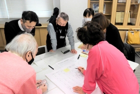 間取り図やカードを使って避難所運営を考える参加者たち＝武庫西生涯学習プラザ