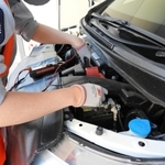 ボンネットを開けて確認するＪＡＦの職員（日産自動車提供）