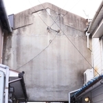 兵庫県尼崎市浜田町５の住宅街を歩いていると、何やら視線を感じた。見上げると…。まな板のような巨大な壁が宙に浮き、路地の空をさえぎっているではないか。もしかして、妖怪「ぬりかべ」？