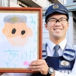 似顔絵を手に笑顔を見せる椋本巡査長＝川西市久代６、川西署久代交番