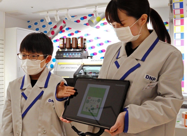 デザインしたフルーツキャンディのパッケージを紹介する児童（左）＝西宮市甲子園八番町、キッザニア甲子園