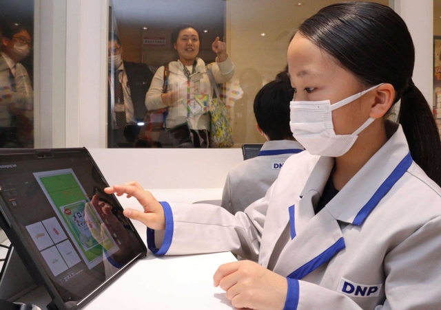 タブレットでフルーツキャンディのパッケージをデザインする児童ら＝西宮市甲子園八番町、キッザニア甲子園