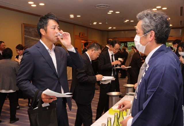 新酒を味わう阪神ＯＢの葛城育郎さん（左）＝西宮市社家町