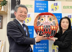 ６選を決め、家族とともに必勝だるまに目を入れて喜ぶ黒川治氏＝尼崎市東七松町１
