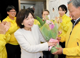 初当選を決め、支援者から花束を受け取る麻田寿美氏＝川西市栄町