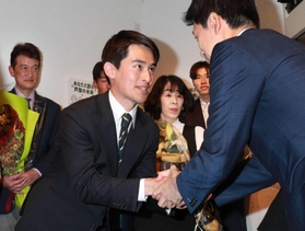 当選確実の一報を受け、駆け付けた近隣の首長らと握手を交わす高島崚輔氏＝芦屋市大原町（撮影・吉田敦史）