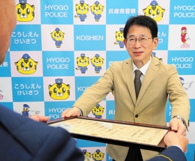 藤原秀憲・甲子園署長から、刑事部長感謝状を受け取る松尾信昭さん＝西宮市甲子園七番町