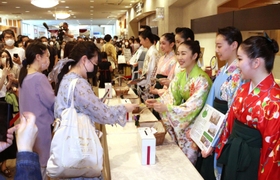 寄付した人にビオラの種を手渡す宝塚音楽学校の生徒ら＝宝塚市栄町１、宝塚大劇場