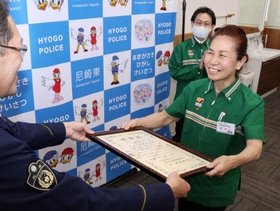 署長感謝状を受け取る「セブン－イレブン尼崎杭瀬本町東店」マネジャーの笠井友子さん（右）＝尼崎市潮江５、尼崎東署