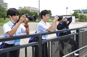 一眼レフカメラなどを使って新聞に載せる写真を撮る（左から）皆川晃太朗さん、奈良侑真さん、川松叶芽さん＝西宮市西宮浜４（撮影・吉田敦史）