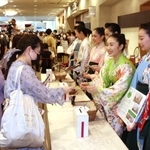 寄付した人にビオラの種を手渡す宝塚音楽学校の生徒ら＝宝塚市栄町１、宝塚大劇場