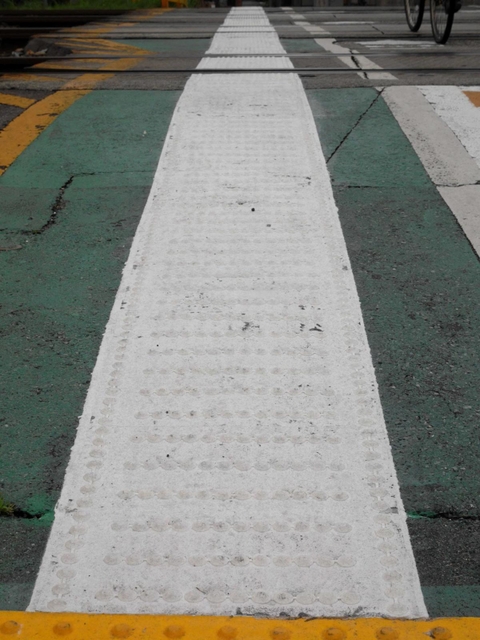 白いラインの上に誘導用の突起が並んでいる＝尼崎市立花町１