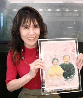 両親の絵を手に動画について語る菊谷早苗さん＝芦屋市船戸町