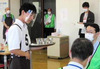 トレーにコップを載せ、接客する喫茶サービス競技の出場者＝ポリテクセンター兵庫（主催者提供）