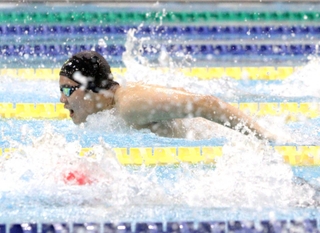 競泳男子２００メートルバタフライで力強く泳ぐ選手＝尼崎スポーツの森