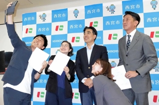 西宮市の広報アドバイザーに就任し、石井登志郎市長と写真を撮る池嶋亮さん（左端）、浅川友里江さん（左から２人目）、山中謙作さん（右端）＝西宮市役所