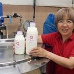 たからづか牛乳の本社工場で製造した牛乳を手にする社長の山本陽子さん＝宝塚市高司５