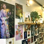 宝塚南口店の店内の壁は、宝塚歌劇のカレンダーやはがきで埋まっている。手前に大きく映るのは花組トップ娘役星風まどかさん＝宝塚市南口２