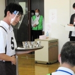 トレーにコップを載せ、接客する喫茶サービス競技の出場者＝ポリテクセンター兵庫（主催者提供）