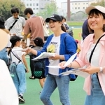 チラシを配る三宅奈緒子さん（右）ら「みんなのあま咲き放送局」のメンバー＝尼崎市西長洲町１