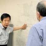 尼崎労働者安全衛生センターの飯田浩事務局長（奥）と話す男性＝尼崎市長洲中通１