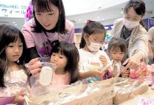 廃棄される花材で手作りしたサシェ（香り袋）を手に取る子どもたち＝西宮市甲子園八番町