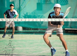 激しい攻防を繰り広げる精道の牧本和来さん、芹口敦紀さんペア＝伊丹スポーツセンター