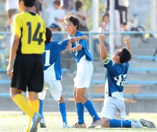 サッカー男子決勝。浜脇に競り勝ち、雄たけびを上げる瓦木の主将能崎賢大さん（右）と決勝ゴールを決めた鎌田航さん（中央）＝西宮浜総合公園ベイコムフィールド（撮影・吉田敦史）