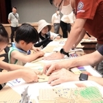 打ち水の前に開かれたイベントで絵が浮き出る「段ボール手紙」を作る子どもら＝尼崎市長洲中通１