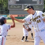 尼崎北ロータリークラブが主催した野球教室で子どもたちを褒める阪神タイガースの前監督、矢野燿大さん＝尼崎市西長洲町１、ベイコム野球場