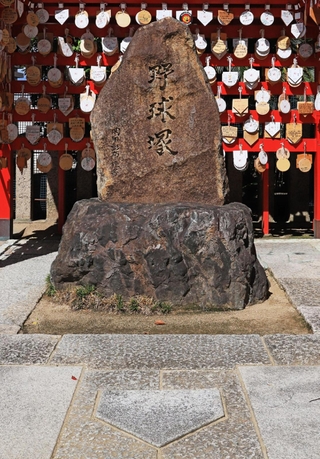 ２００２年に故・星野仙一監督が参拝したことがきっかけで設置されたホームベース形の敷石（手前）と、０４年に岡田彰布監督の揮毫で造られた野球塚＝西宮市甲子園町、甲子園素盞嗚神社