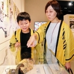 選手のグラブなどの展示品に見入る阪神ファンの親子＝西宮市甲子園町