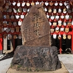 ２００２年に故・星野仙一監督が参拝したことがきっかけで設置されたホームベース形の敷石（手前）と、０４年に岡田彰布監督の揮毫で造られた野球塚＝西宮市甲子園町、甲子園素盞嗚神社
