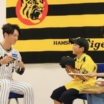 阪神タイガースの近本光司外野手（左）から色紙や帽子にサインをもらった板垣諒士郎君（中央）と母理絵子さん＝西宮市甲子園町（撮影・吉田敦史）