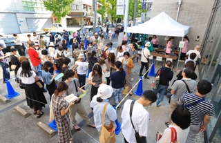 プレミアム付き商品券の発売開始前から長い列をつくる人たち＝西宮市南越木岩町
