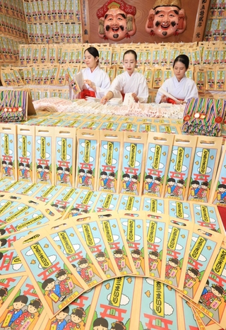 千歳あめの袋詰めを進める巫女たち＝西宮市社家町
