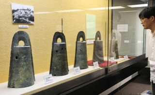 弥生時代に祭りで使われたとされる銅鐸が並ぶ会場＝辰馬考古資料館